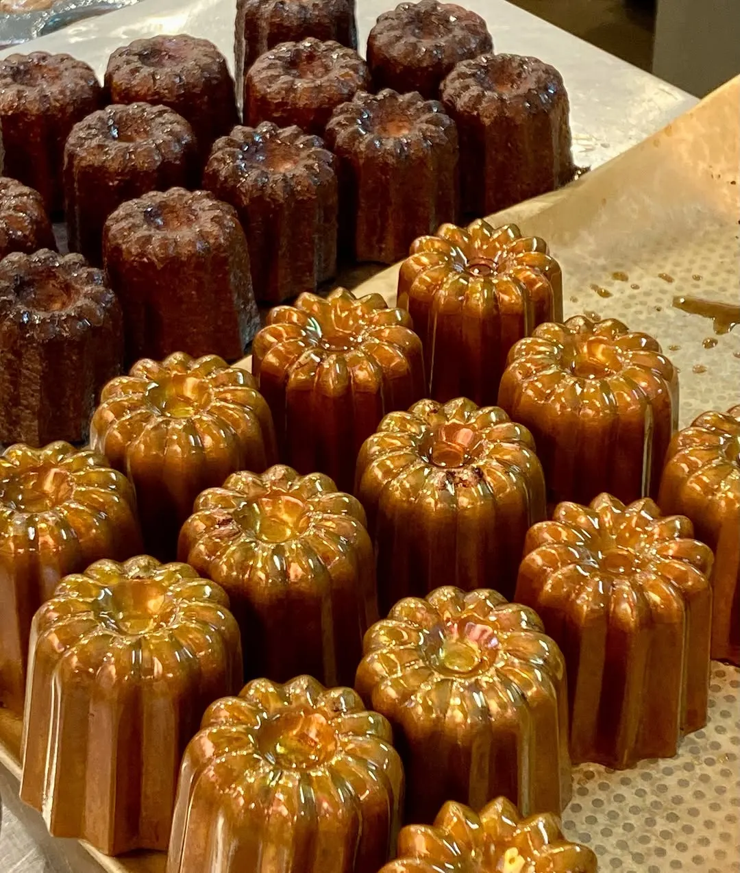 Canelé glistening in copper moulds, fresh from the bake