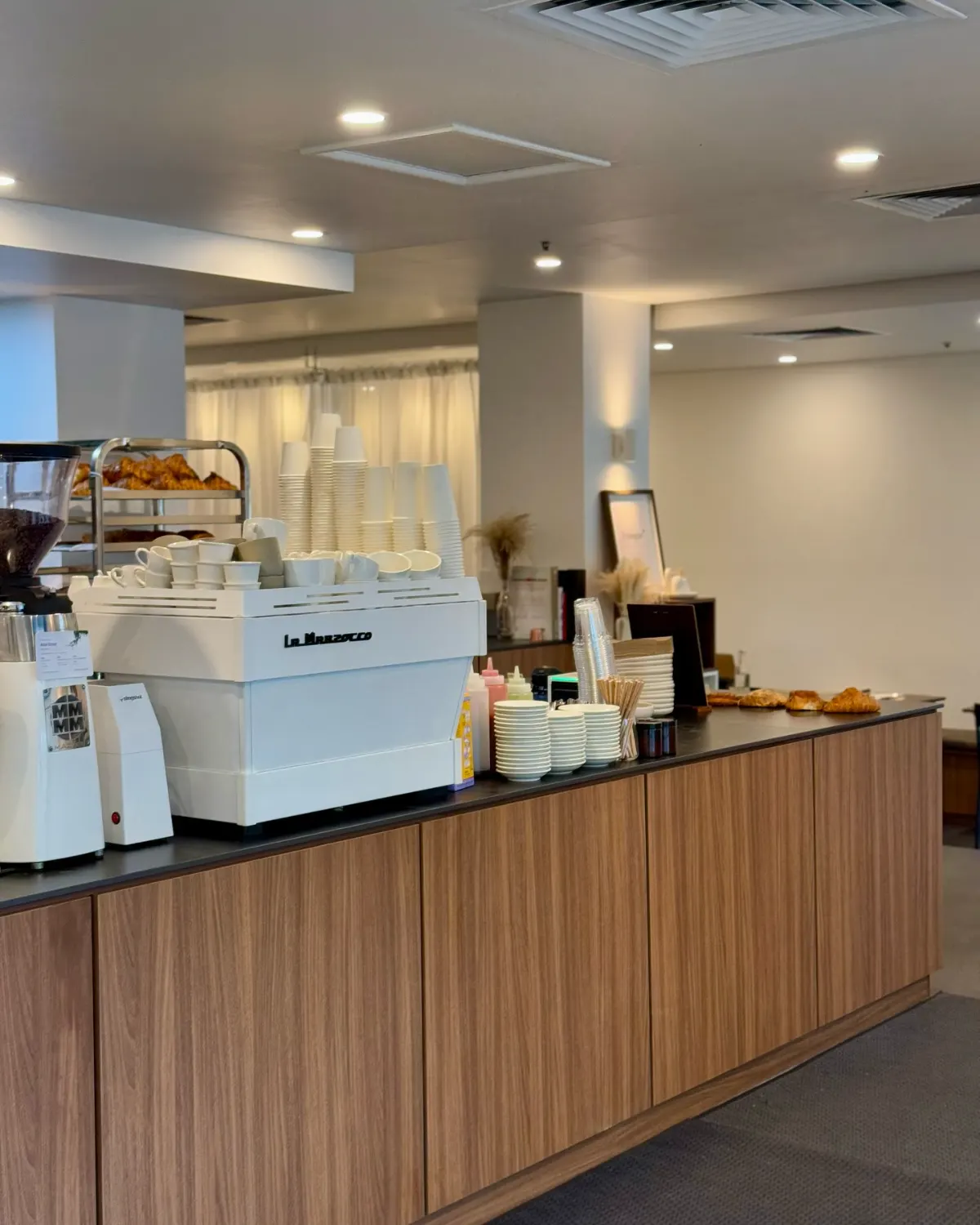 The Prologue counter with a white La Marzocco machine and warm wood joinery