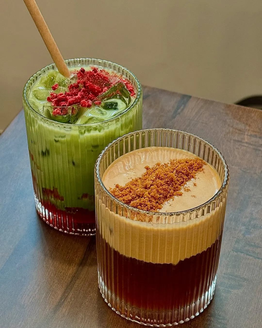 Iced berry matcha beside a biscoff-cream cold brew